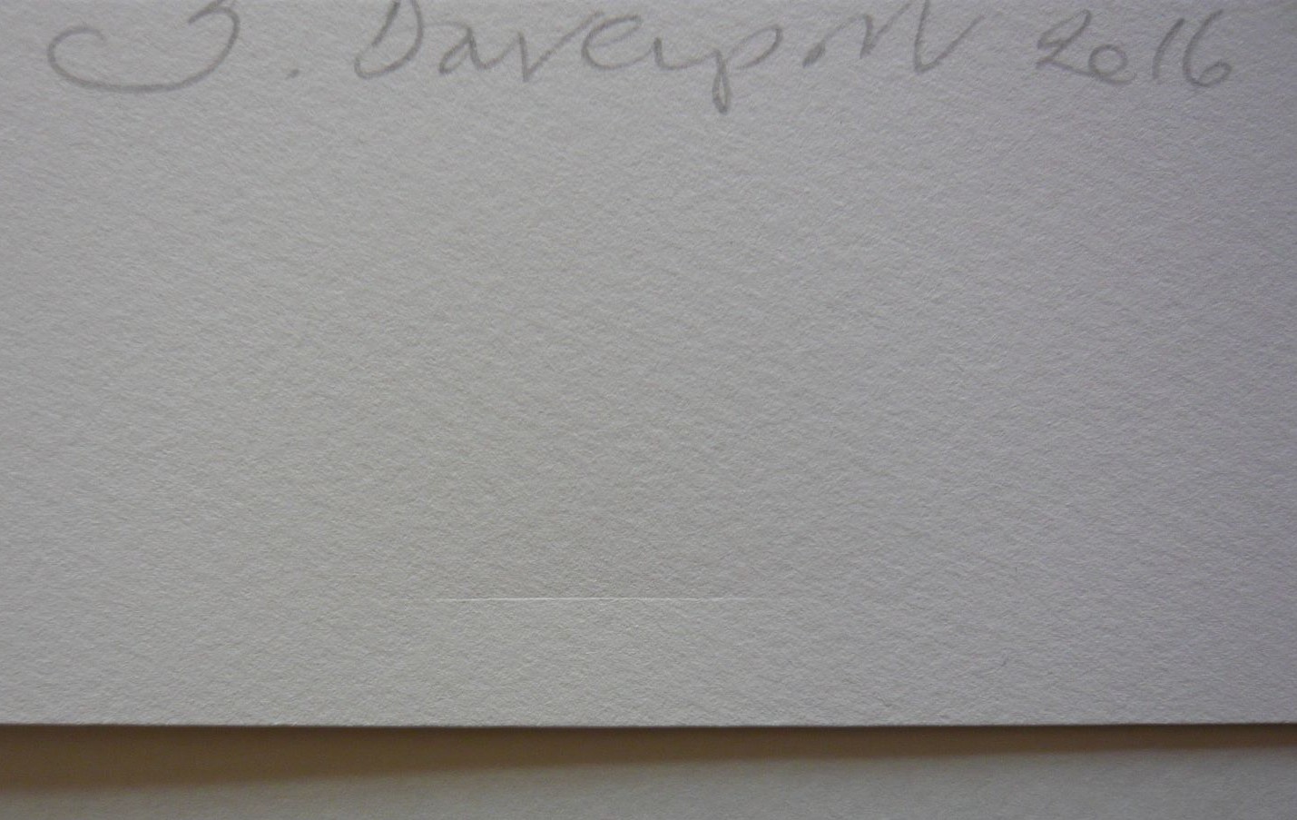 A dent in the paper of a print, before treatment